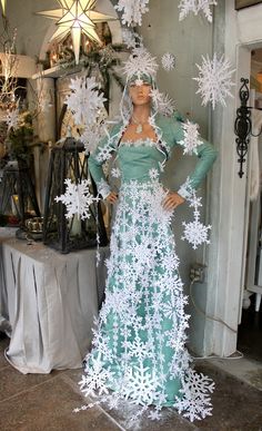 a mannequin dressed in a dress made out of paper snowflakes