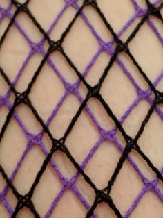 a cell phone that is laying on some kind of netted material with purple and black lines