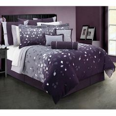 a bed with purple and white comforters in a room