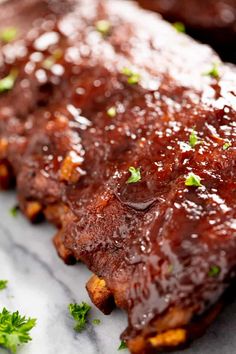 ribs covered in bbq sauce and garnished with parsley on the side