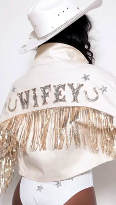 a woman wearing a white cowboy hat and gold sequins on it's jacket