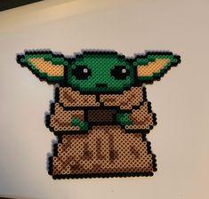 a lego star wars yoda sticker sitting on top of a white table next to a laptop computer