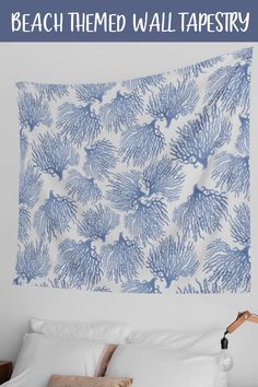 a blue and white wall tapestry hanging over a bed