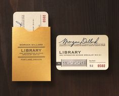 a library card and ticket sitting on top of a wooden table