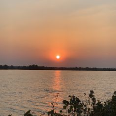 the sun is setting over some water