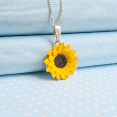 A bright, cheerful pendant necklace featuring the British summer garden favourite,this beautifully carved and painted Sunflower Pendant necklace brings out natures beauty. A perfect adornment to enhance many outfits and a wonderful gift to brighten the day. Designed, hand made in a resin mixture and carefully hand painted in fine quality acrylic pigments by the partners in their rural  Welsh studios.The pendant measures 23 mm (1 inch )  with a choice of 18 inch, 16 inch or 12 inch fine curb chai Hand Painted Flower Necklace For Gift, Yellow Necklace With Birth Flower Pendant, Yellow Birth Flower Pendant Necklace, Hand Painted Flower Pendant Necklace As Gift, Hand-painted Flower Pendant Necklace For Gift, Hand Painted Yellow Jewelry For Gift, Yellow Polymer Clay Jewelry For Gifts, Yellow Flower-shaped Necklaces For Gifts, Yellow Flower Shaped Necklaces For Gifts