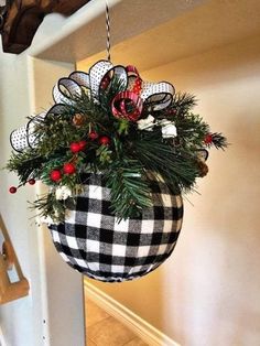 a potted plant hanging from the side of a wall with christmas decorations on it