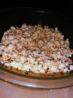 a bowl filled with popcorn sitting on top of a wooden table