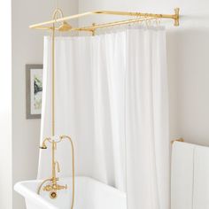 a bathtub and shower in a white bathroom with gold fixtures on the faucet