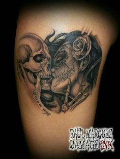 a couple of skulls on the back of a woman's thigh with roses in her hair