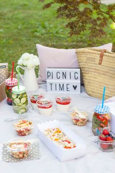 a picnic table is set up with food and drinks for the guests to enjoy in