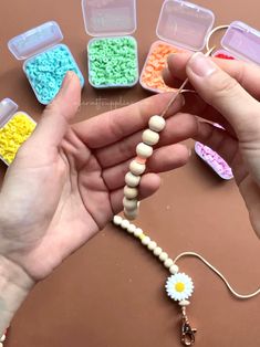 a person holding beads in their hands and some other items on the table next to them