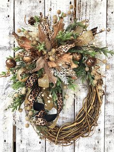 a wreath with leopard print and pine cones on it, sitting against a wooden wall