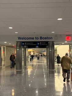 people are walking through an airport terminal with their suitcases in hand and there is a sign that says welcome to boston