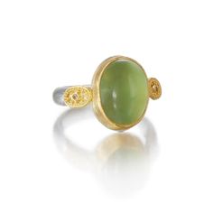 Gold, Silver & Stone Ring - Greek goddess Gaia, ancestralmother of the Earth, is the inspirationfor this exquisite ring. Its enchantingprehnite cabochon is set in 22K goldand fl anked by granulated ovals,while the 0.15W band is brushedsterling silver. Whole and half sizes6-12. Yellow Gold Jade Cabochon Ring, Yellow Gold Jade Ring With Gemstone, Spiritual Yellow Gold Oval Opal Ring, Yellow Gold Chrysoprase Emerald Ring For Anniversary, Yellow Gold Emerald Ring With Chrysoprase For Anniversary, Green Oval Prehnite Rings, Heirloom Jade Rings In Yellow Gold, Heirloom Yellow Gold Jade Rings, Exquisite Green Cabochon Ring