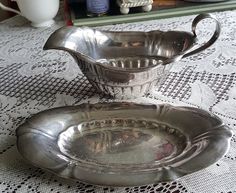 two silver dishes sitting on top of a table