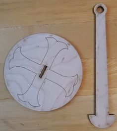 a white clock sitting on top of a wooden table next to a metal wrench