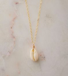 "Unleash your inner beach goddess with our Natural White Cowrie Shell Necklace! Handcrafted with a creamy-white cowrie shell, this piece is more than just a necklace--it's a conversation starter, a part of the ocean, a symbol of strength and prosperity. Perfect to uplift any outfit and designed to transport you to sunny shores, this necklace is sure give you summer vibes all year round.  We hand-make each necklace to order with a natural Cowrie shell that's set onto your choice of a sterling sil White Shell Charm Necklace Gift, Dainty Strand Jewelry For The Beach, Dainty Strand Jewelry For Beach, Dainty Strand Beach Jewelry, Dainty Shell Charm Necklace For Beach, White Ocean-inspired Charm Necklace For Gift, Ocean-inspired White Charm Necklace As Gift, Ocean-inspired White Charm Necklace Gift, White Shell Jewelry For Beach Season