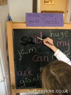 a child writing on a blackboard with magnets