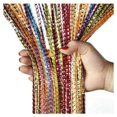 a hand holding a bunch of multicolored bracelets