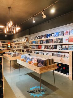 a record store with lots of records on the shelves and lights hanging from the ceiling