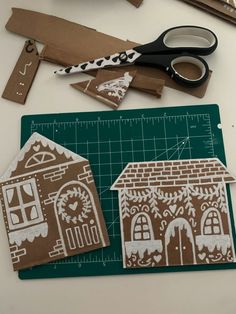 paper cutouts are sitting on a cutting board next to scissors and other crafting supplies