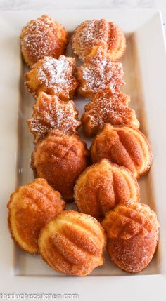 several pastries on a white plate with powdered sugar