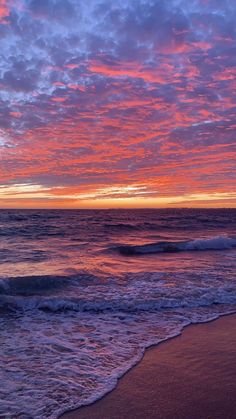 the sun is setting over the ocean with waves coming in