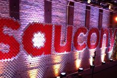 a wall made out of plastic bottles with the word coca cola spelled on it in red and white