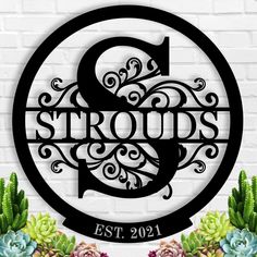 personalized metal monogrammed sign with succulents in front of a brick wall