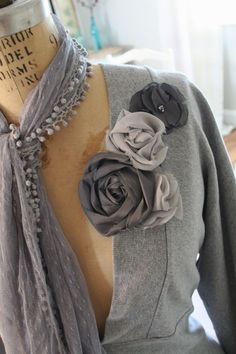 a mannequin wearing a gray jacket with flowers on it