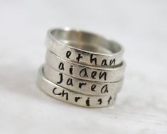 Hand forged, hand stamped with letters, shaped, soldered, and hand finished. - Engraved with up to 15 characters - Band is 3mm wide by 1mm thick - .925 solid sterling silver - Please include personalization (name) on checkout page, notes section For sizing help: if purchasing multiples to wear together, it's best to order approx 1/2 bigger than the normal size ring you would wear. MY SHOP ♥ http://LustrousElements.etsy.com JOIN ME ON FACEBOOK ♥ to hear about Specials and Promotional Give-Aways h Sterling Silver Hand Stamped Stackable Rings As Gift, Hand Stamped Sterling Silver Stackable Rings As Gift, Personalized Name Sterling Silver Stackable Rings, Personalized Silver Ring With Name, Meaningful Engraved Silver Stackable Rings, Silver Hand-stamped Engraved Ring, Silver Engraved Name Ring For Birthday, Sterling Silver Name Rings For Birthday, Silver Engraved Ring With Name For Birthday