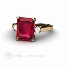 "A beautiful three stone Ruby engagement ring with a gorgeous 4.25ct emerald cut lab grown Ruby. There are two natural diamonds, one on each side of the center stone, .14 carats total weight. Simply stunning. Ruby is the birthstone forJuly. Available in 14K or 18K White, Yellow or Rose Gold and Platinum. Made to order. Please allow three to four weeks for delivery. Inquire for the matching wedding band. Lab grown Rubies are physically, chemically and optically identical to natural sapphires. The Formal Three Stone Emerald Cut Ruby Ring, Formal Emerald-cut Ruby Ring With Three Stones, Formal Emerald Cut Three-stone Ruby Ring, Gift Emerald Ring With Three Stones In Radiant Cut, Three Stone Ruby Engagement Ring, Irish Promise Rings, Simple Wedding Bands, Ruby Engagement Ring, Emerald Engagement Ring Cut