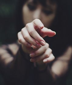 a woman holding her hand out to the camera