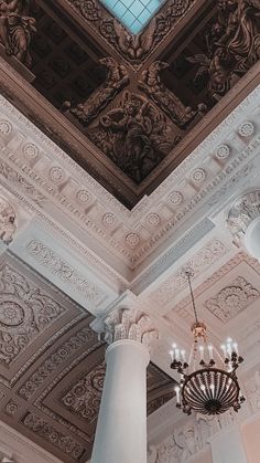 a chandelier hangs from the ceiling in an ornately decorated room with painted ceilings