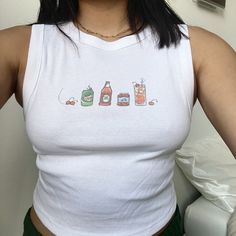 Aperol Spritz Baby Tee/Tank. Hand-drawn drink recipe for the cocktail. Check out my shop for more drinks, pop culture, and music inspired items! Shirt material is 50/50 cotton and polyester. Multicolor ink on White/Cream Clothing Each item is uniquely printed and designed by me! Available on: White Boxy Baby Tee, Estimated Women's Sizing: XS, S, M White Cropped Tank, Women's Sizing: XS, S, M, L, XL, XXL White T-Shirt, Unisex Sizing: S, M, L, XL, XXL More Sizing Available! (Made to order, Message me for XXL+ sizes) Wash instructions: Turn inside out, wash with cold water and delicate setting. Air dry preferred. Follow specific care instructions to ensure the longevity of the design for all handmade items. Check out my Instagram and Depop for customer photos and reviews. Message me with any Fitted Graphic Print Cute Tank Top, Fun Summer Tops With Graphic Design, Retro Graphic Print Tank Top, Retro Screen Print Tank Top For Summer, Fun Cotton Tops With Graphic Design, Retro Tank Tops With Letter Print, Crew Neck Cotton Printed Tank Top, Printed Cotton Crew Neck Tank Top, Cotton Printed Crew Neck Tank Top