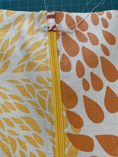 an orange and white fabric with yellow zippers