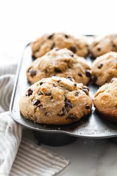 freshly baked chocolate chip cookies in a baking pan on a marble counter top, ready to be eaten