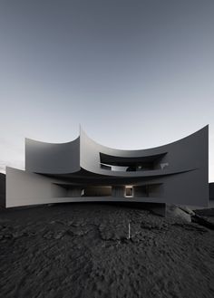 an architecturally designed building sits in the middle of a barren area with no people around it