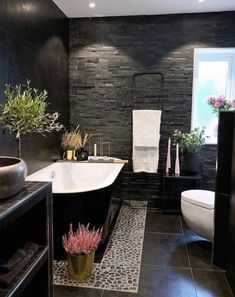 a black and white bathroom with stone walls