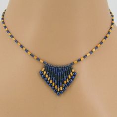 a blue and yellow beaded necklace on a mannequin neckpiece with beads