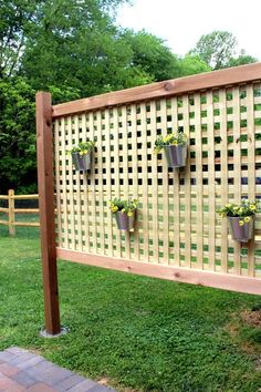 a wooden trellis with potted plants on it