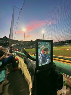 a baseball game is being played on the tv screen in an empty bleachers