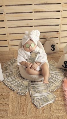 a baby doll sitting on top of money