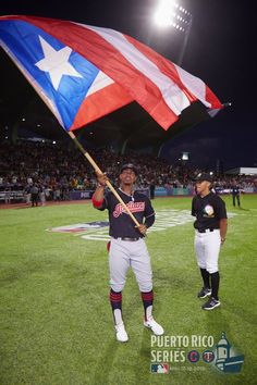 a baseball player holding a flag on top of a field