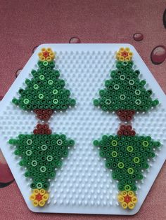 two christmas trees made out of legos sitting on top of a table