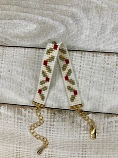 a pair of keys hanging from a chain on top of a wooden table with white and red fabric