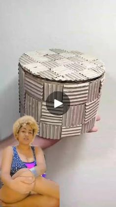 a woman sitting on top of a stool next to a box shaped like a basket