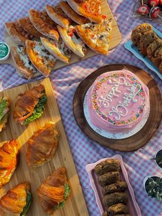 a table topped with lots of cakes and desserts next to plates filled with pastries