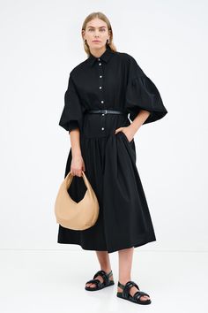 Meet our Ada Dress, the ultimate warm weather staple. She's a midi shirtdress handcrafted from 100% European poplin cotton, featuring pockets and a dropped gathered waistline that falls over your frame with ease. Her clean lines and sharp collar harmonize with dramatic dropped shoulders and full-bodied sleeves, elevating your style for any occasion.[SPLIT] Maritza, in black and in light blue, is 5'9.5" (177 cm) tall, wearing size XS. Shannon, in white, is 5'8" (173 cm) tall, wearing a size M. Mi Chic Poplin Workwear Dresses, Black Poplin Dress Outfit, Elegant Summer Poplin Dress, Elegant Oversized Button-up Dress, Black Poplin Dress, Tunic Hoodie, Abayas Fashion, Black White Red, A Line Dress